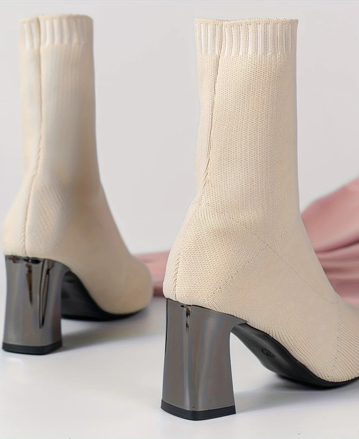 Full length view of black high heel sock boots, featuring an elegant block heel and pointed toe. Stylish women's footwear.