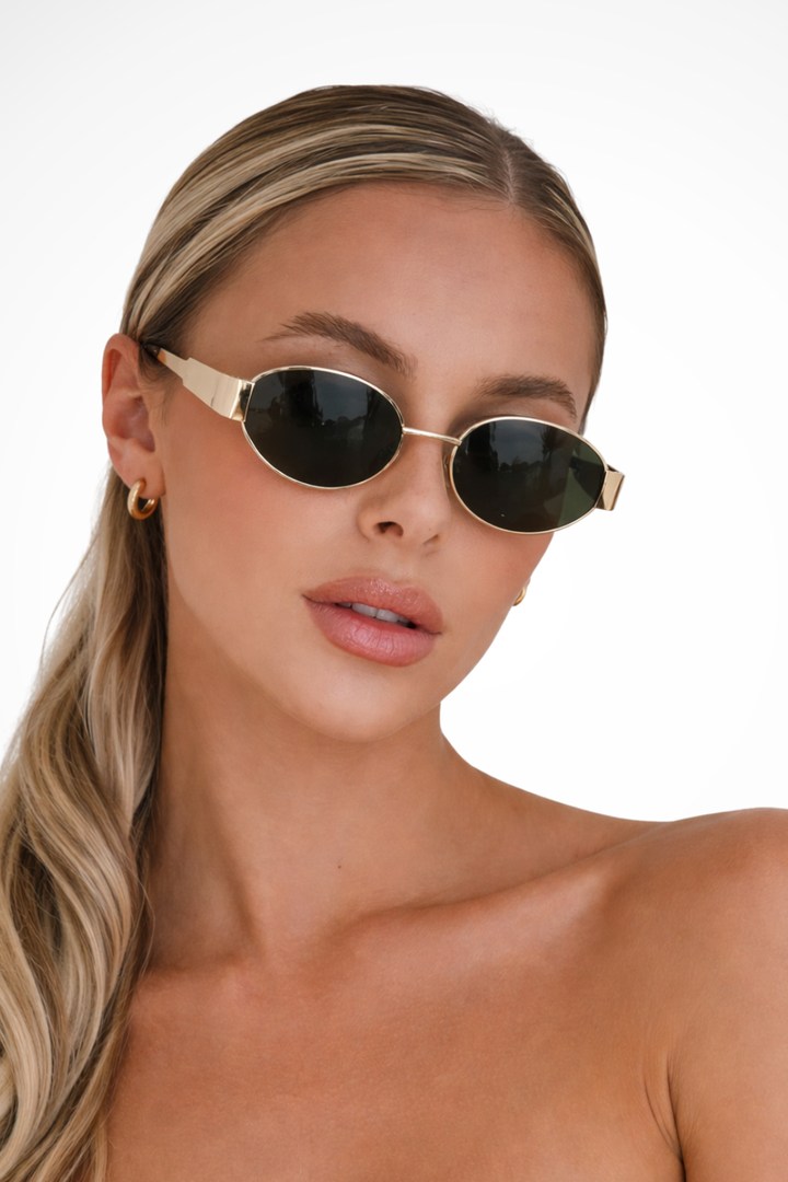 Women's chic oval metal frame sunglasses with dark tinted lenses, offering stylish UV protection for summer.