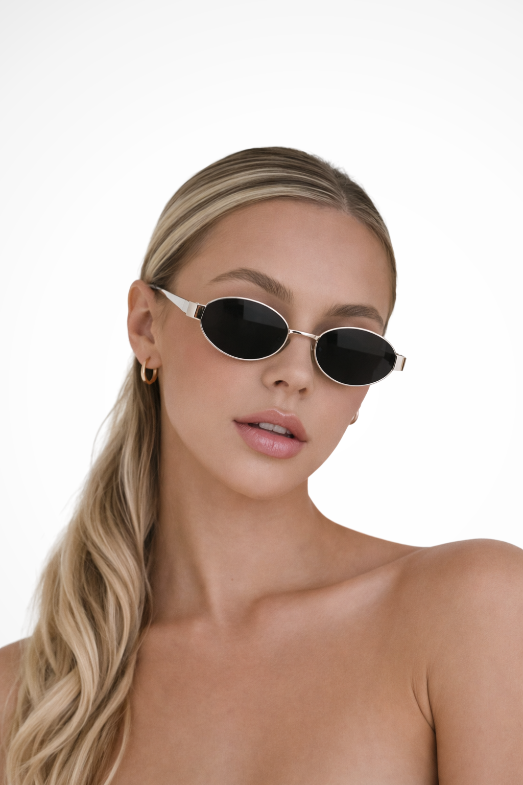 Close-up of women's oval metal frame sunglasses, showcasing the dark lenses and minimalist design.