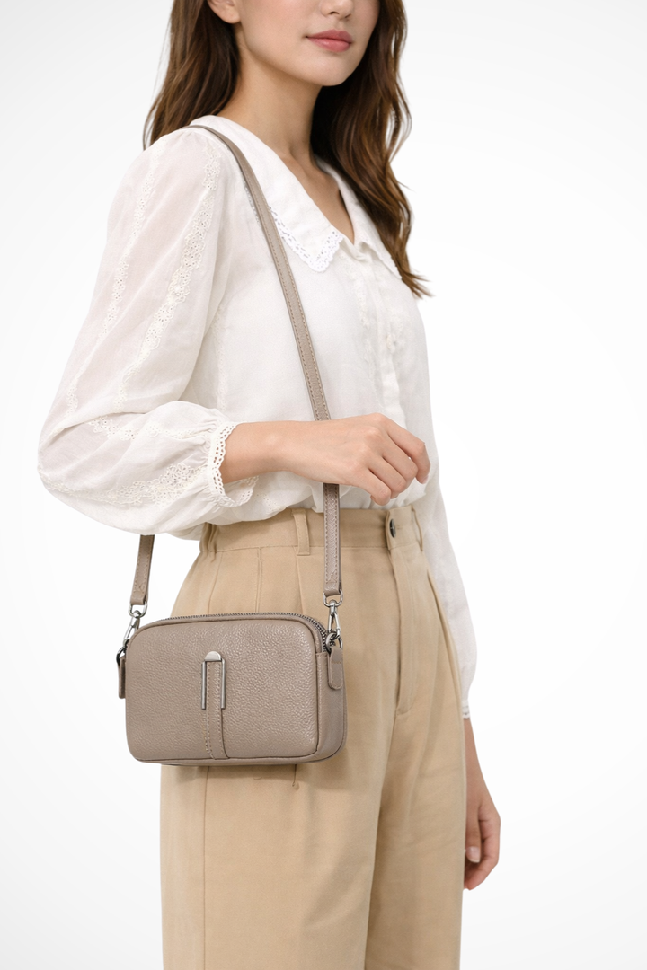 Textured women's compact handbag, double zip for secure storage, easily converts to shoulder or crossbody.