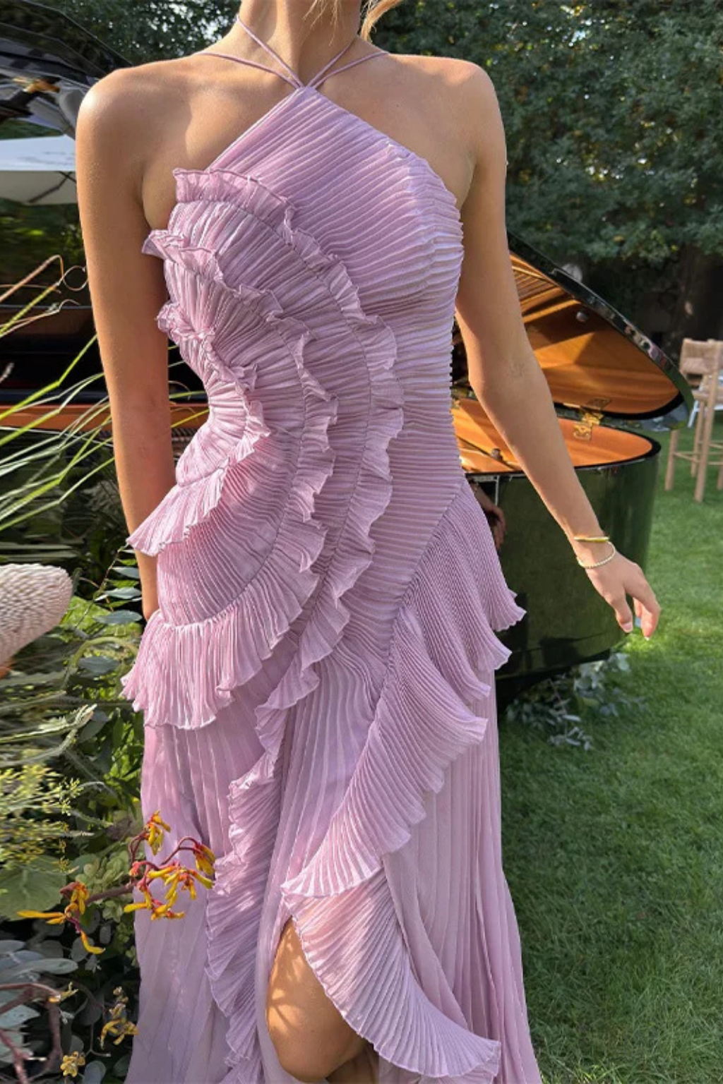 Women's fashion backless ruffled halter maxi dress. Elegant summer event wear with pleated details.