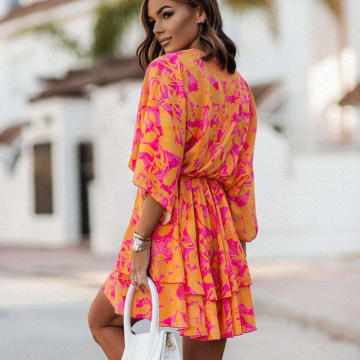 Orange floral mini summer dress for women, featuring a ruffle hem, V-neck, perfect for casual or holiday wear.