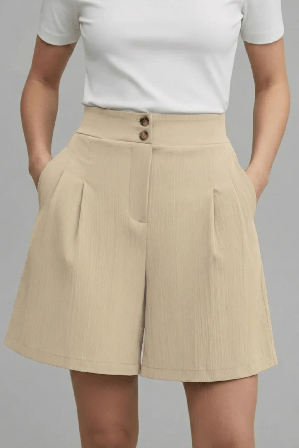 Women's fashionable high-waist pleated Bermuda shorts, button front detail.