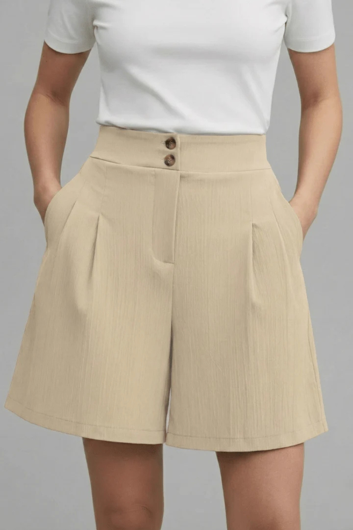 Women's fashionable high-waist pleated Bermuda shorts, button front detail.