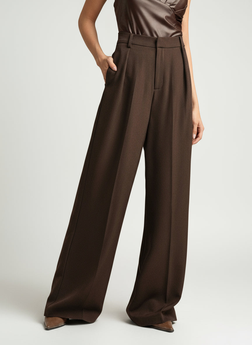 Model posing in high waist wide leg tailored trousers, showing versatility and style.