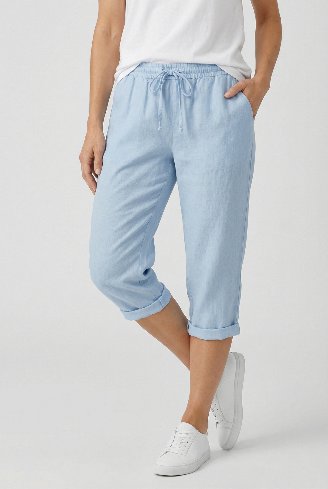 Woman enjoying summer in comfortable, casual linen capri trousers with an elasticated waist.