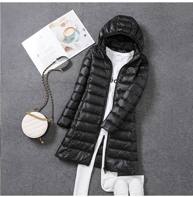 New women's long puffer jacket, a modern winter coat with a sleek design and a cozy detachable hood for ultimate warmth.