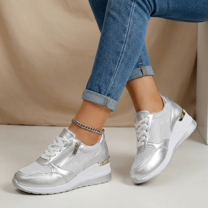 Fashionable women's wedge trainers. Metallic gold sneakers with side zip, offering comfort & chic style.