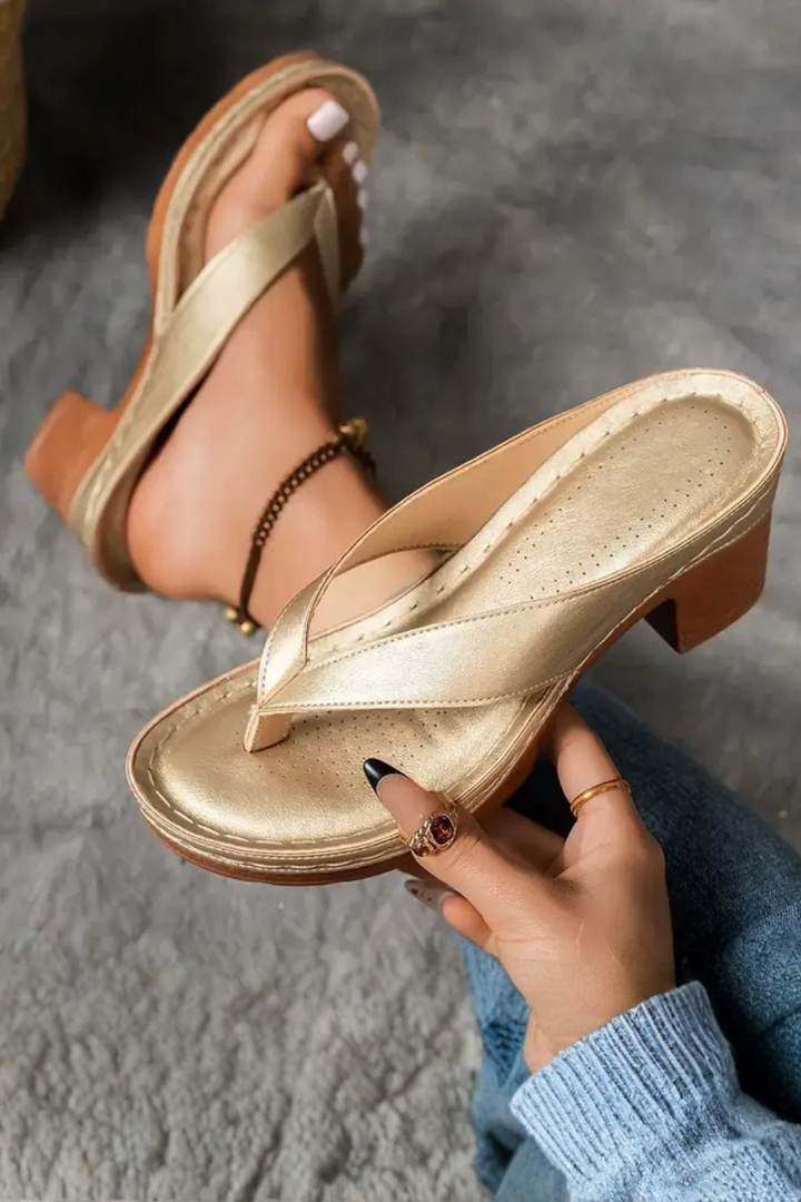 Close-up of elegant women's metallic toe post sandals with a comfortable block heel.