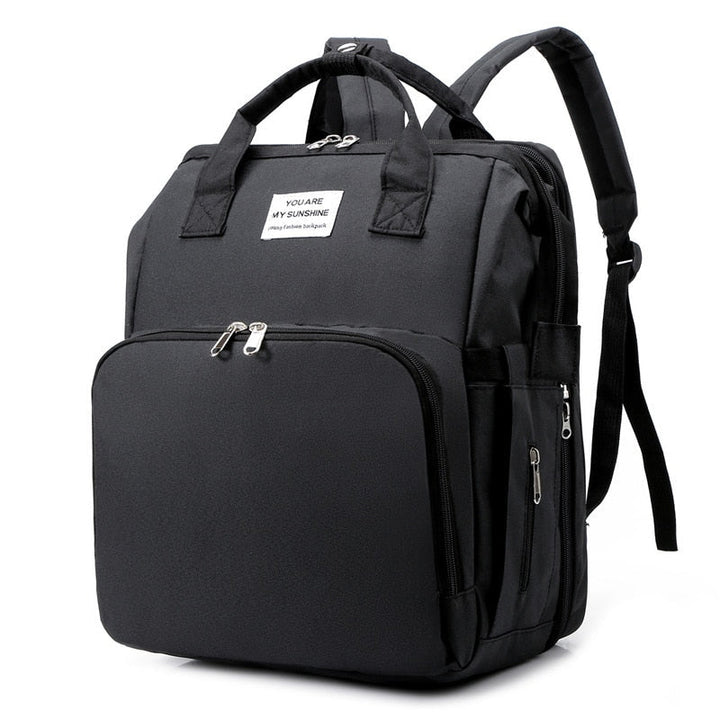 Women's multi-function diaper backpack with integrated portable baby bed for on-the-go parents.
