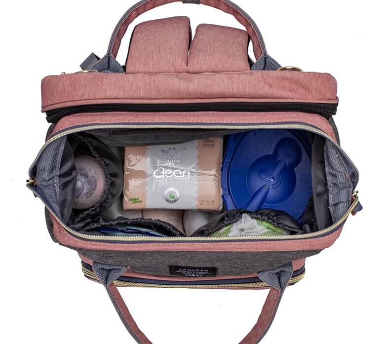 Women's multi-function nappy bag with a fold-out portable baby bed, perfect for infant travel.