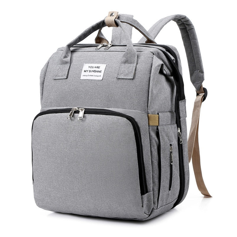 Convenient women's travel backpack with pop-out portable baby changing station and bed.
