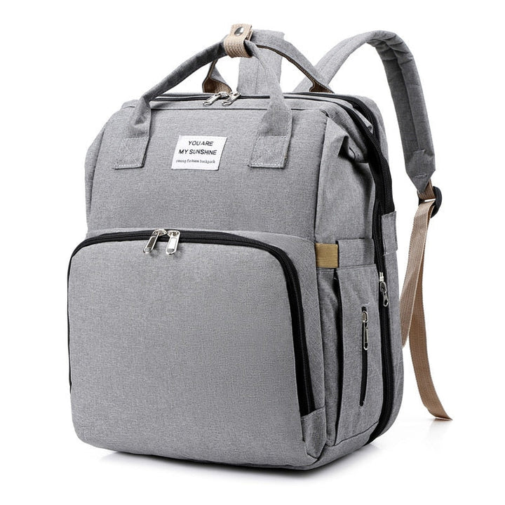 Convenient women's travel backpack with pop-out portable baby changing station and bed.