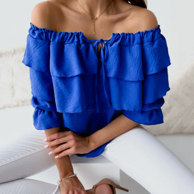 Woman modeling an elegant off-shoulder tiered ruffle blouse with long sleeves & tie-front. Stylish smart casual top.