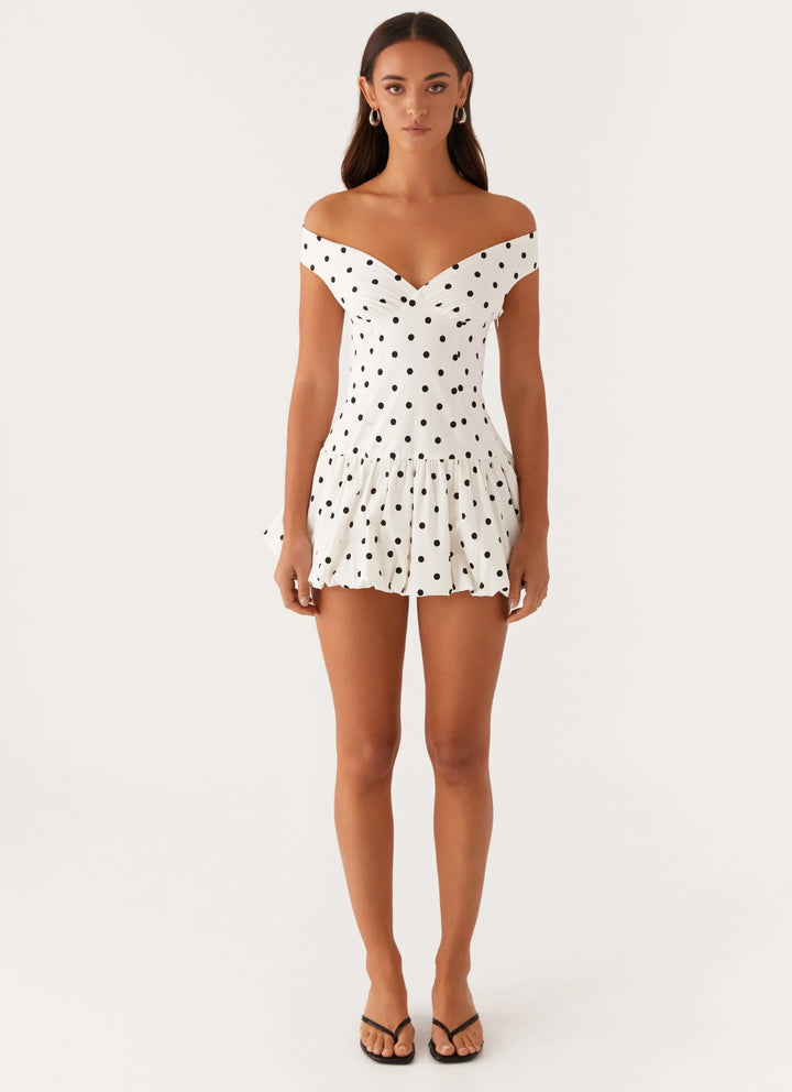 Chic high-waist off-shoulder polka dot peplum mini dress for a flattering silhouette.