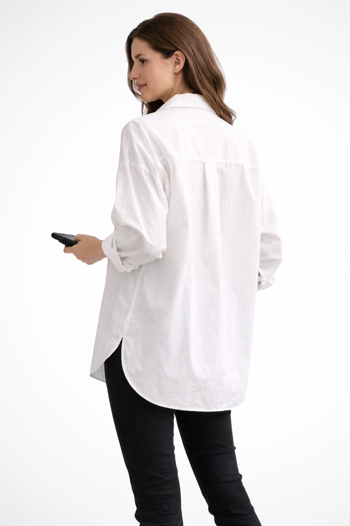 Modern women's long-sleeve button-down blouse in white, offering an oversized and relaxed fit for daily fashion.