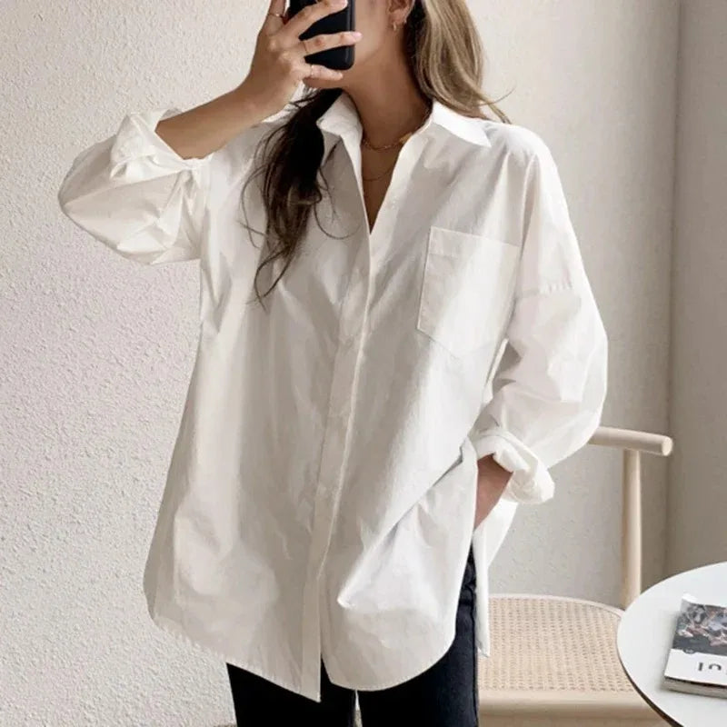 Crisp white women's oversized button-down blouse. Long-sleeve casual shirt with a relaxed, modern aesthetic.