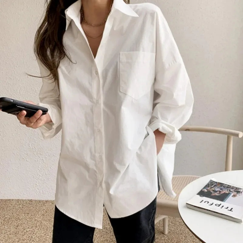 Elegant women's white button-down long-sleeve blouse. Oversized and relaxed fit for chic casual outfits.