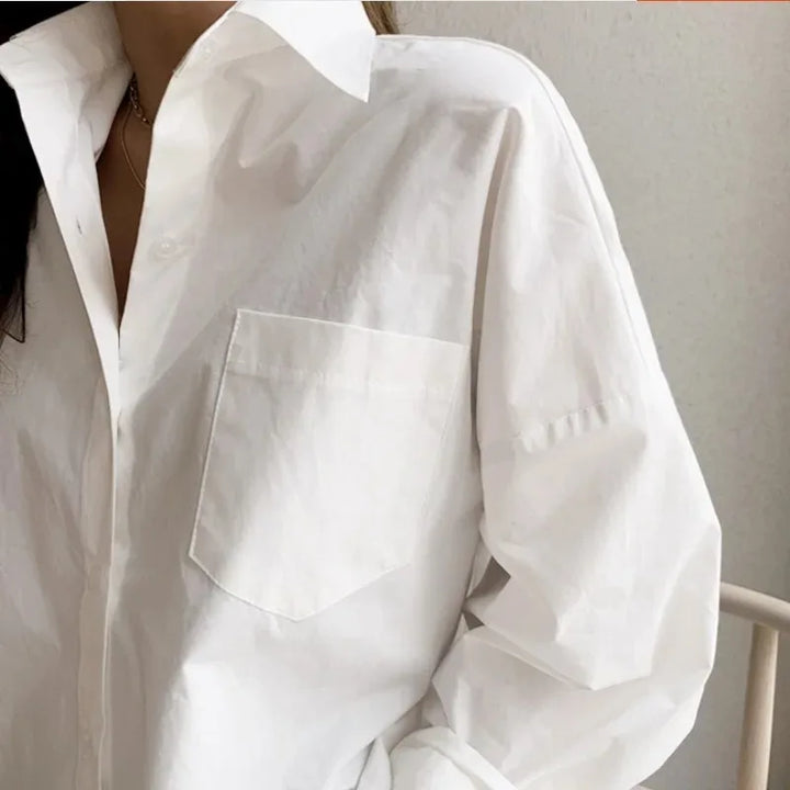 Fashionable white oversized long-sleeve blouse. Women's casual button-down top with a relaxed, modern fit.