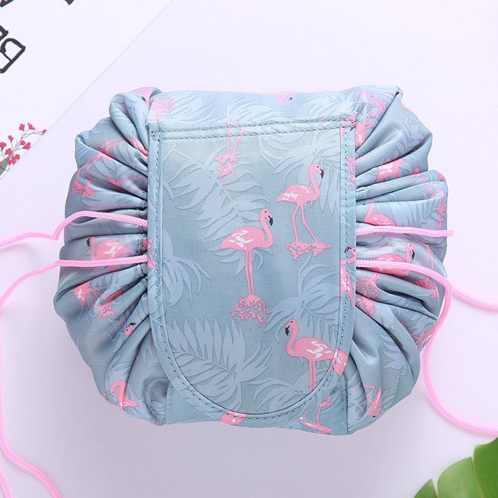Open drawstring cosmetic bag showing organized makeup, brushes & toiletries, perfect for travel.