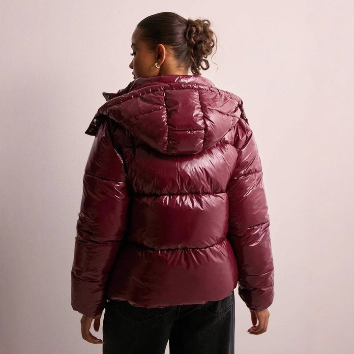 Glossy women's quilted jacket in a stylish design. Chic everyday outerwear with a versatile detachable hood.