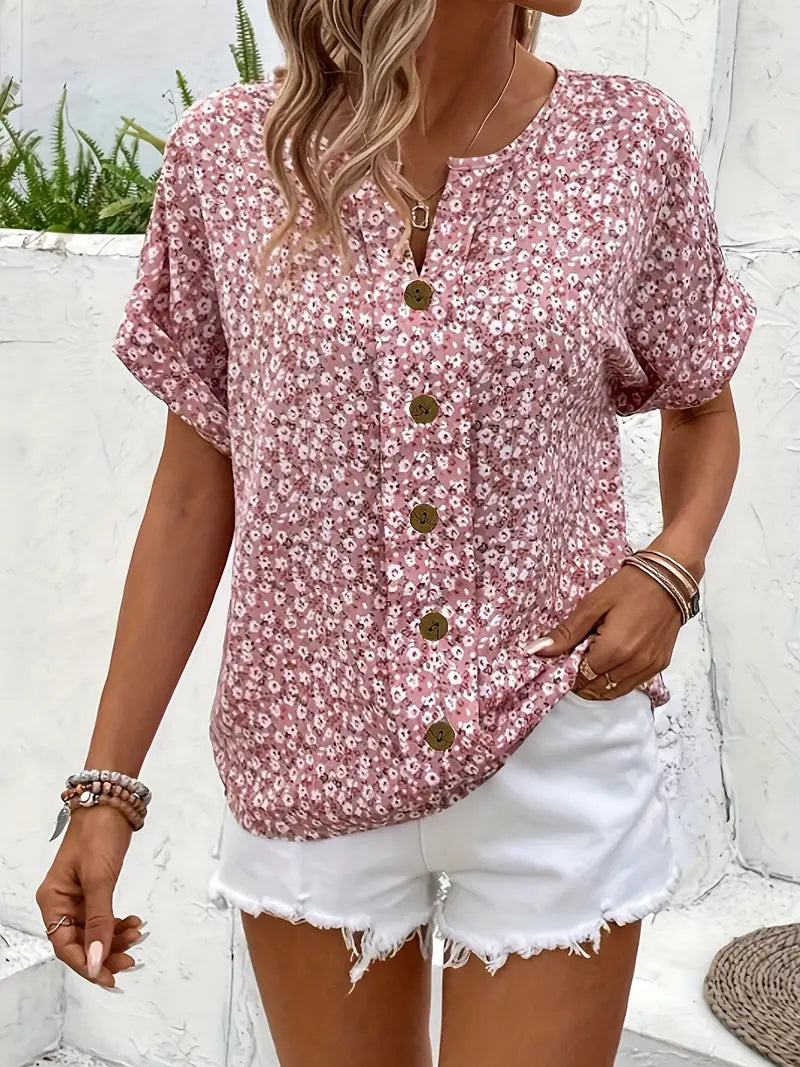 Chic women's pink blouse with delicate floral print and button-down front, ideal for warm weather style.