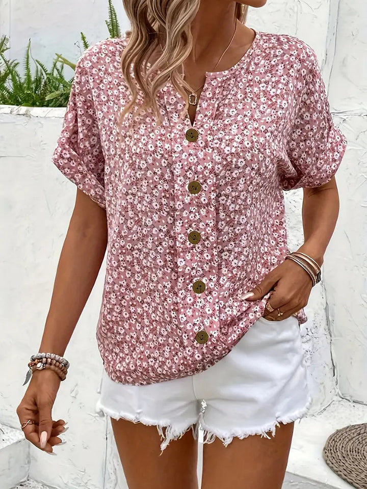 Chic women's pink blouse with delicate floral print and button-down front, ideal for warm weather style.