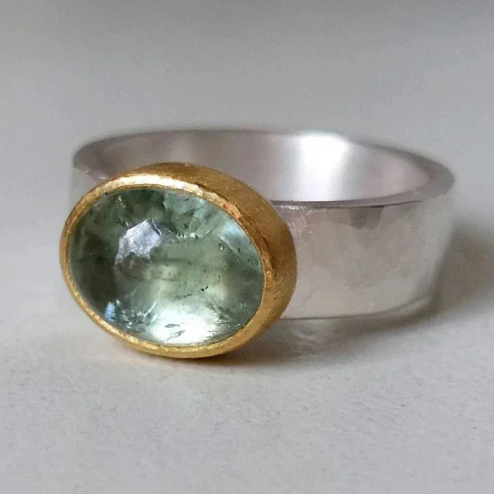 Women's vintage hammered silver-tone ring with an oval green stone & elegant gold bezel. Stylish fashion accessory.