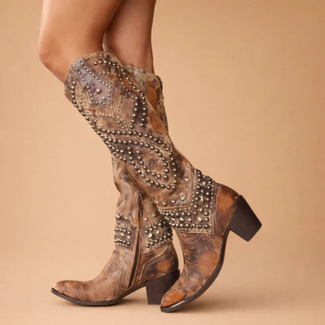 Women's vintage knee-high cowboy boots with classic Western stitching & studded details. Perfect for bold fall fashion.