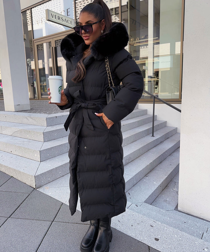 Stylish women's maxi length puffer coat with a flattering belt. Perfect outerwear for a chic winter look.