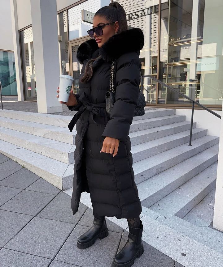 Back view of a women's belted maxi puffer winter coat. Long, warm, and stylish outerwear for cold days.