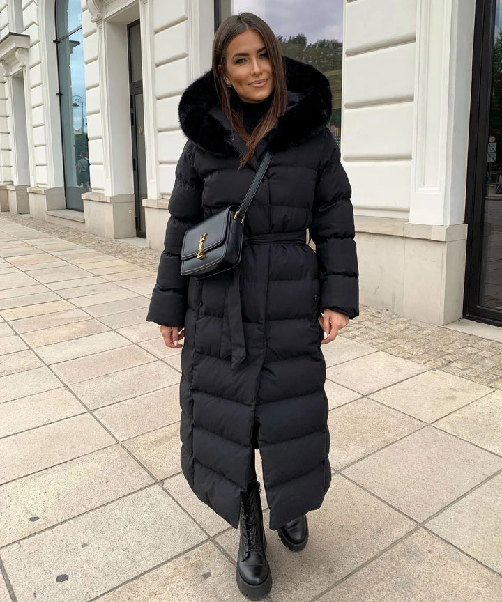 Warm women's belted puffer winter coat, maxi length. Essential cold weather outerwear for stylish protection.