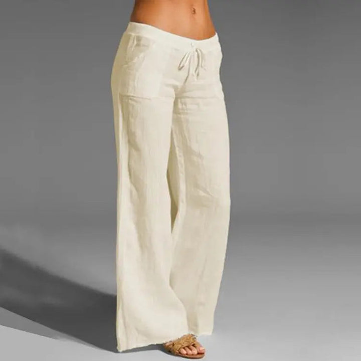 Women's white linen blend loose-fit summer trousers with elastic waist, ideal for casual wear & warm weather comfort.
