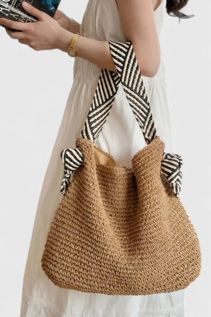 Lightweight women's woven straw beach bag, a versatile casual shoulder tote with contrast straps.
