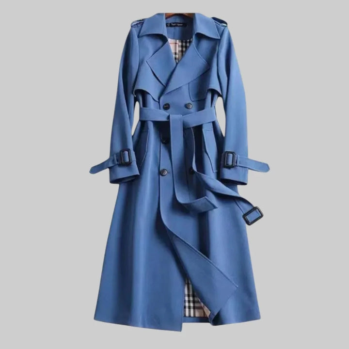 Classic women's long beige double-breasted trench coat, featuring a stylish belted waist & timeless design.