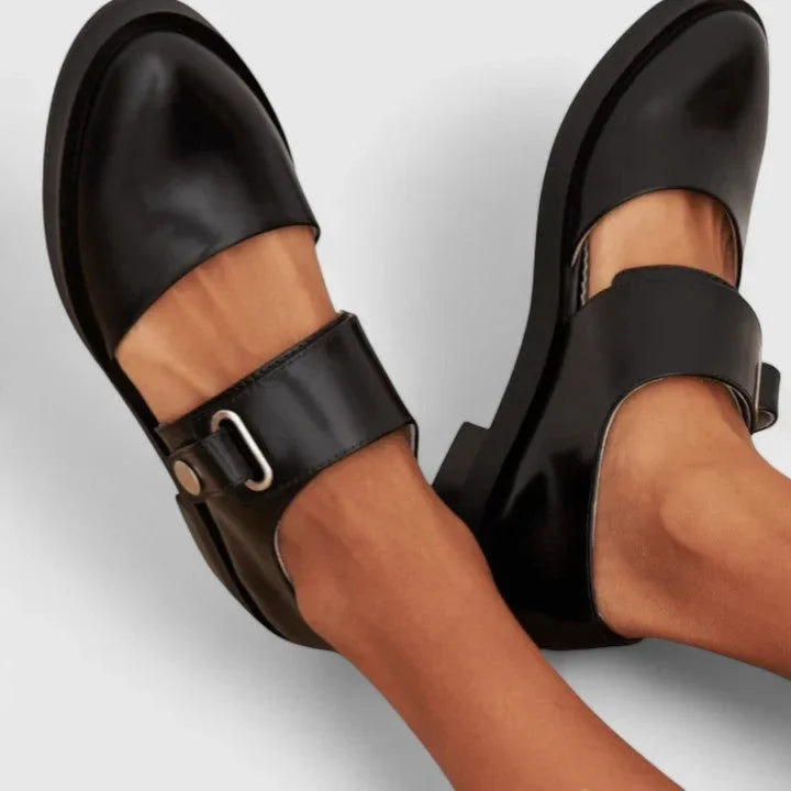 Women's black Mary-Jane flats with elegant side cut-outs. Comfortable classic style for work or everyday wear.