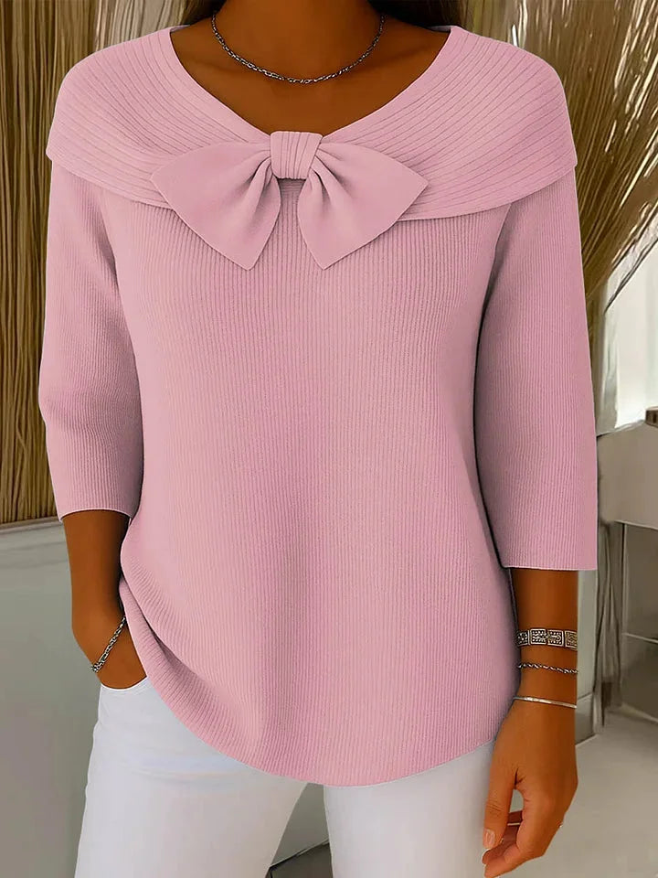 Pink V-neck sweater for women, featuring a chic bow detail & 3/4 sleeves. Versatile and elegant top.