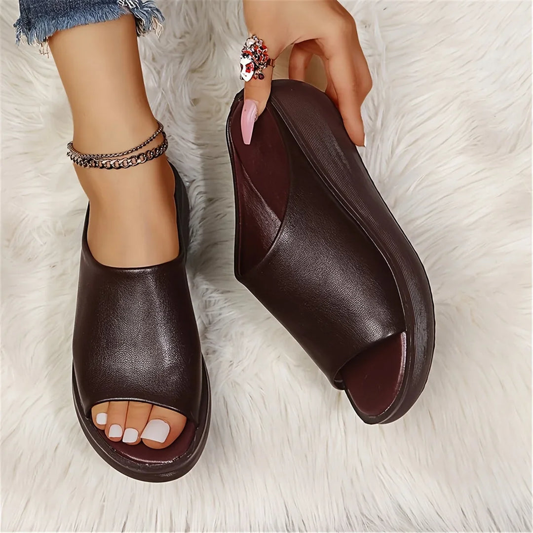 Elegant brown slip-on wedge sandals for women. Open-toe design, perfect for chic summer outfits and comfort.