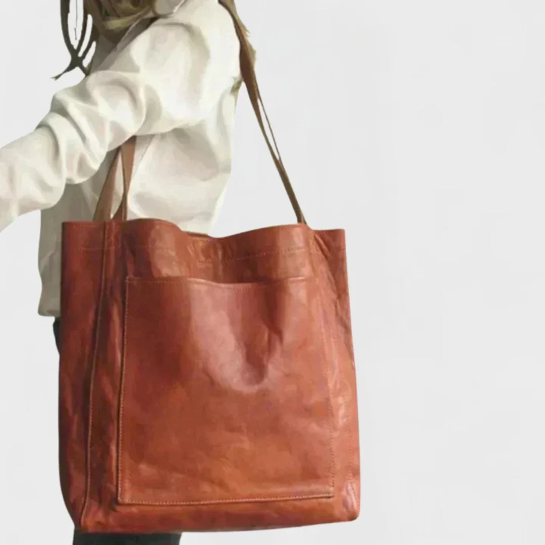 Versatile women's brown leather tote bag, perfect as an everyday shoulder bag with a functional front pocket.
