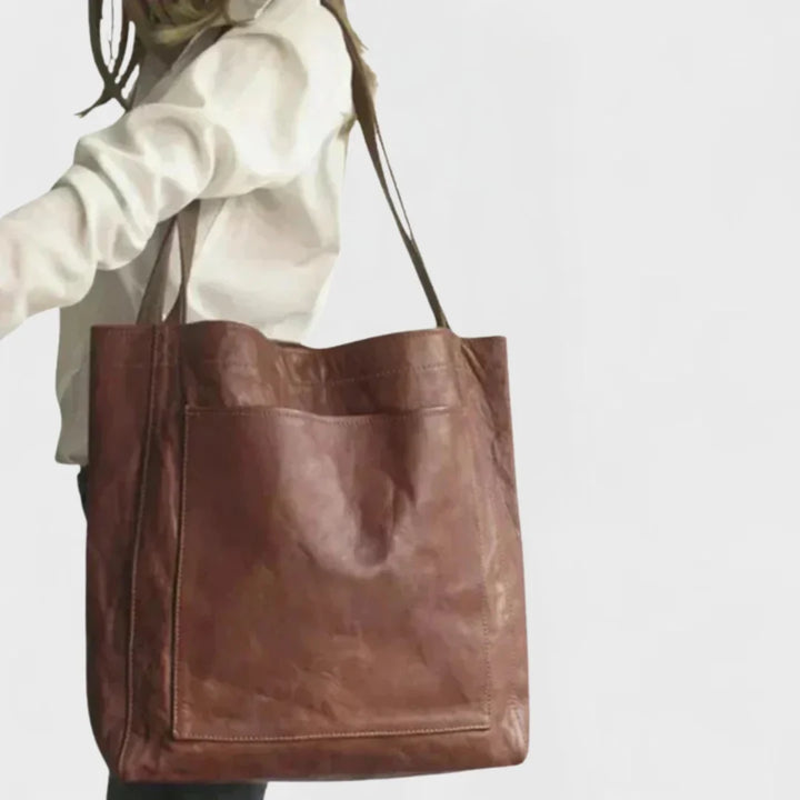 Chic brown leather everyday bag for women, a spacious tote with a stylish front pocket and comfortable handles.