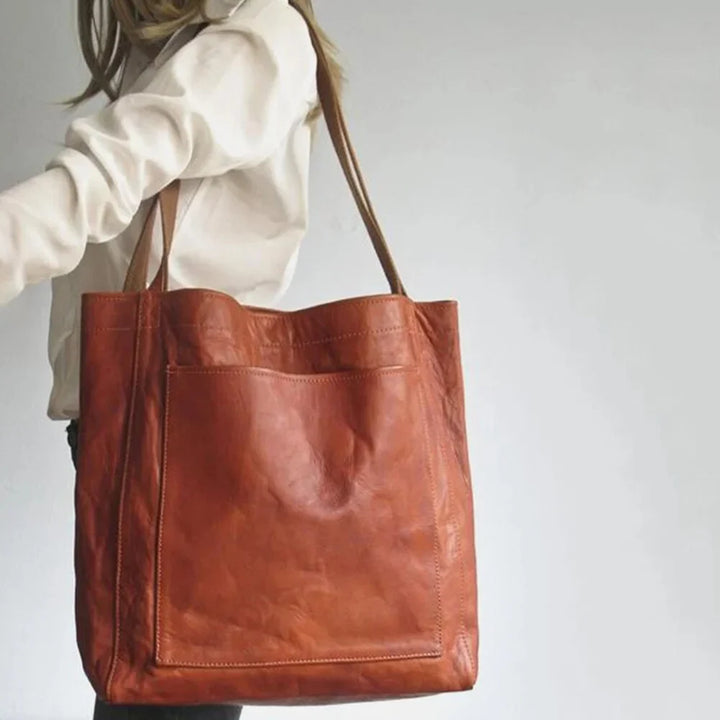 Spacious & stylish women's dark brown leather tote bag with magnetic snap closure and practical front pocket.