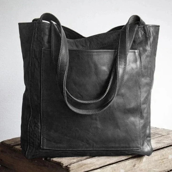 Genuine brown leather tote handbag for women, featuring a secure magnetic snap and handy front patch pocket.