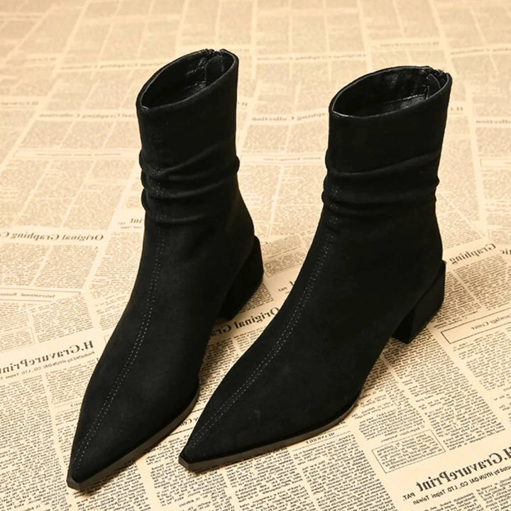 Close-up of women's brown slouchy ankle boots, highlighting the elegant pointed toe & stable block heel design.