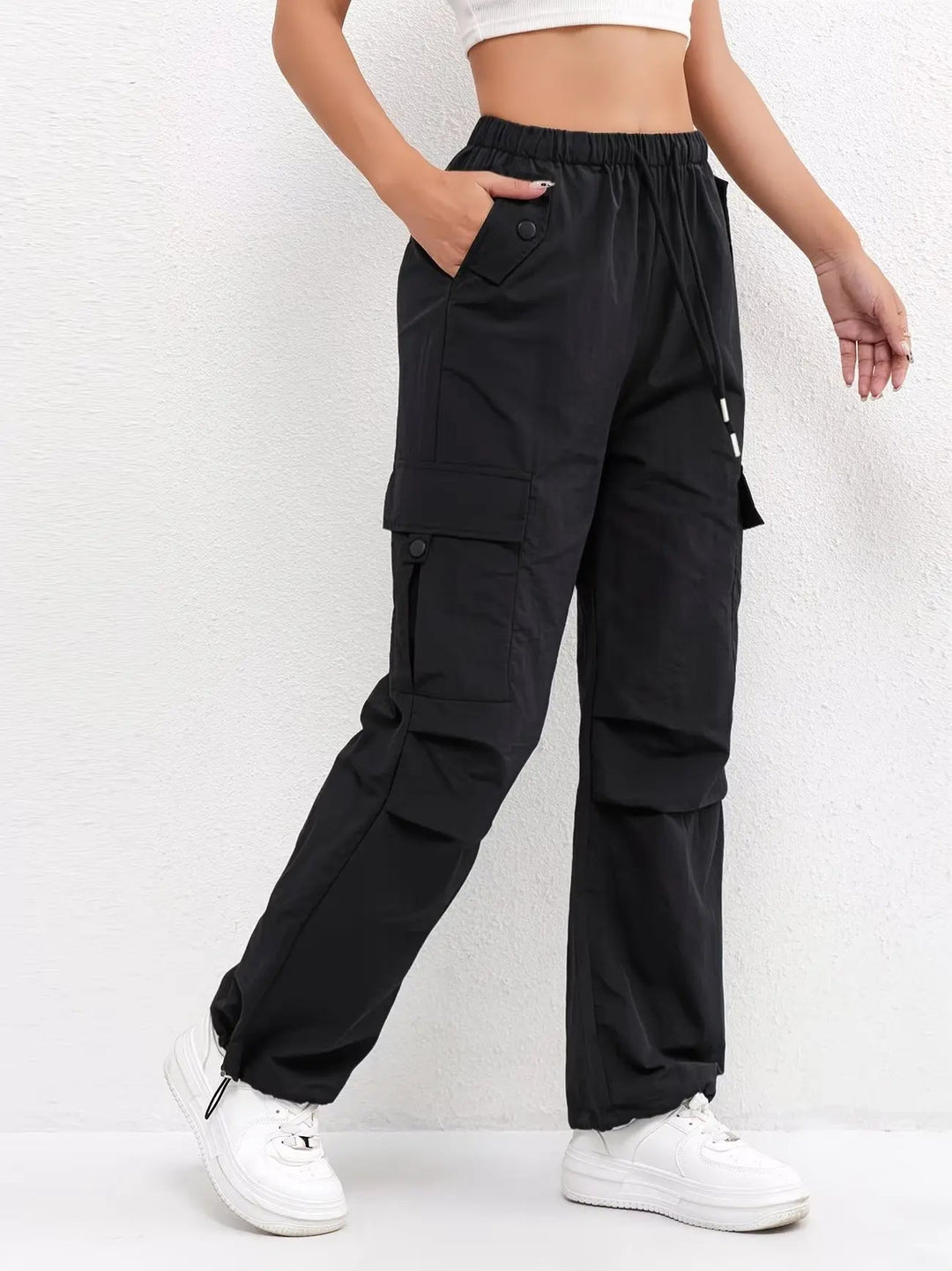 Close-up of women's utility parachute cargo pants, showing adjustable drawstring waist, belt loops & side pockets.