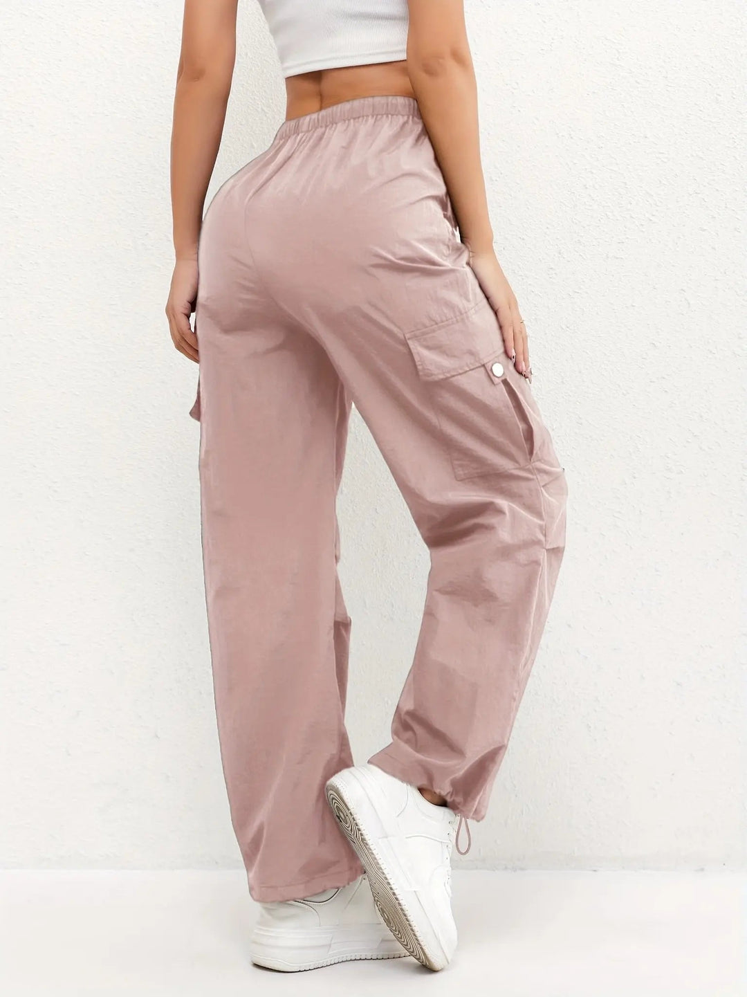 Folded women's parachute style cargo trousers, highlighting multi-pockets, adjustable waist & durable fabric.