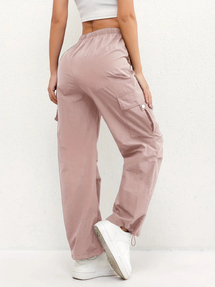 Folded women's parachute style cargo trousers, highlighting multi-pockets, adjustable waist & durable fabric.