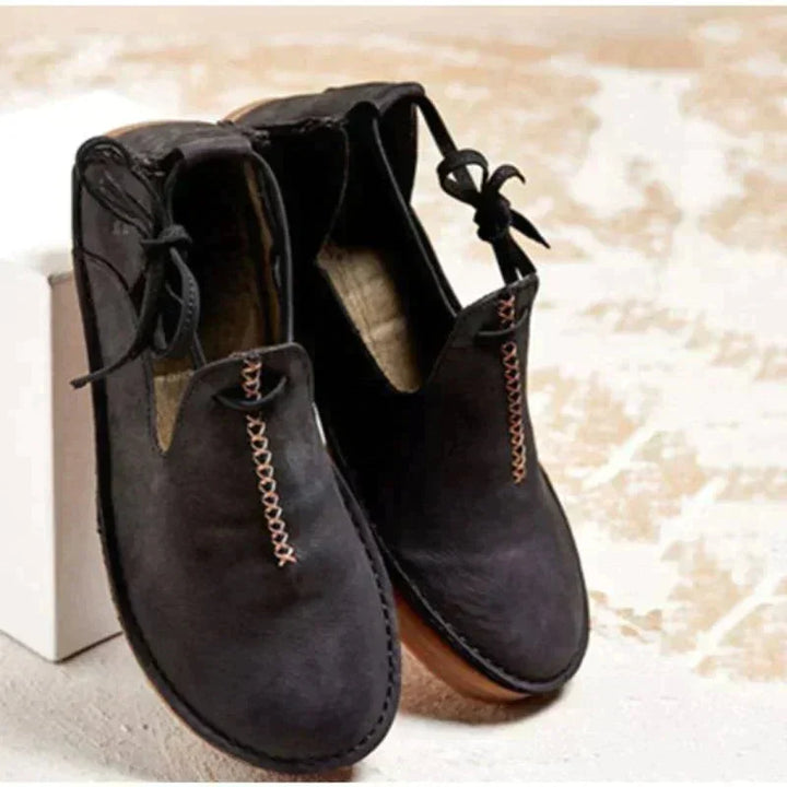 Stylish women's round-toe flats featuring unique lace-up design & intricate decorative stitching.