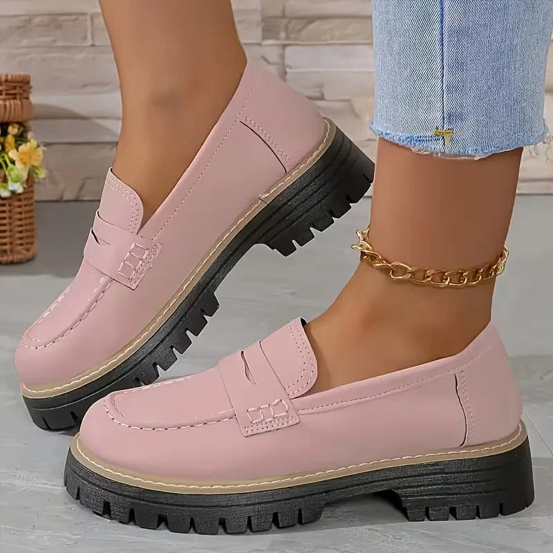 Stylish black chunky platform loafers for women. Slip-on penny strap design for office wear or casual comfort.