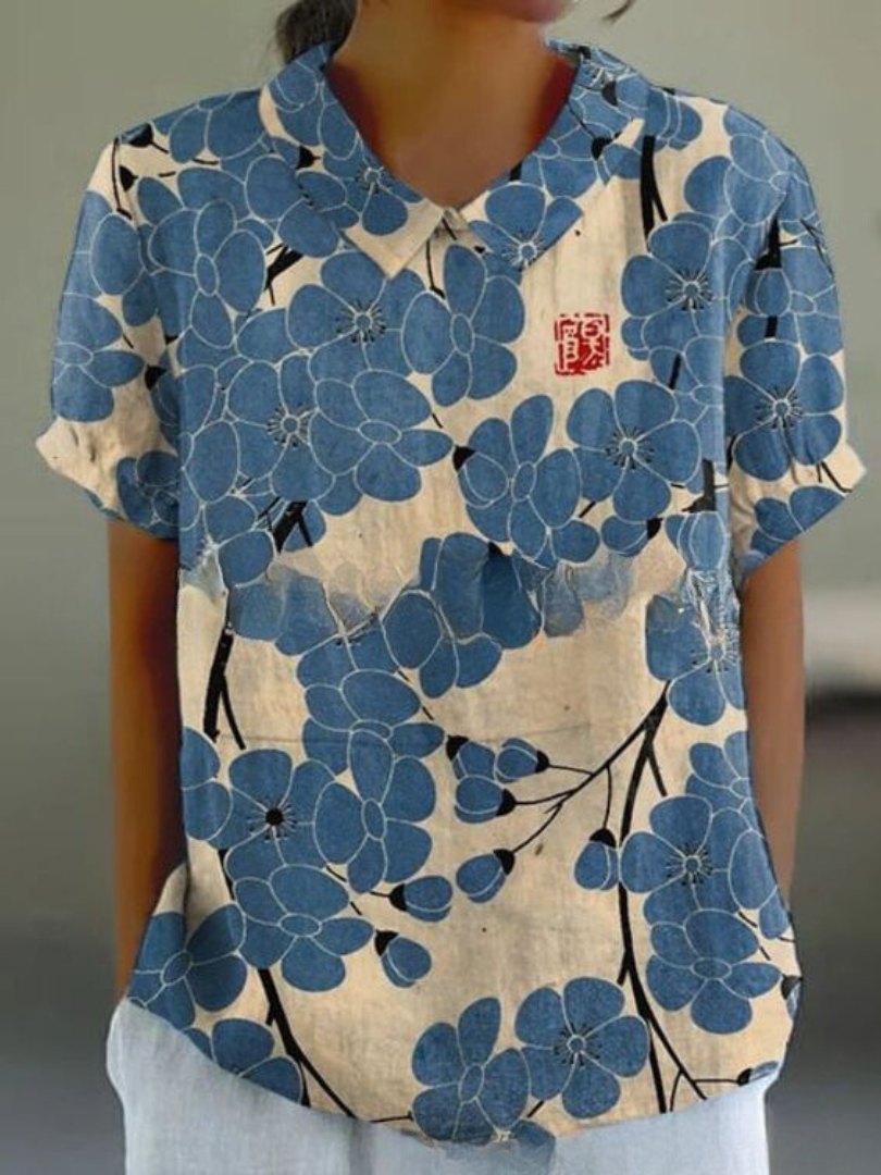 Women's elegant floral blouse with short sleeves and Peter Pan collar, featuring a vibrant floral pattern for stylish summer 