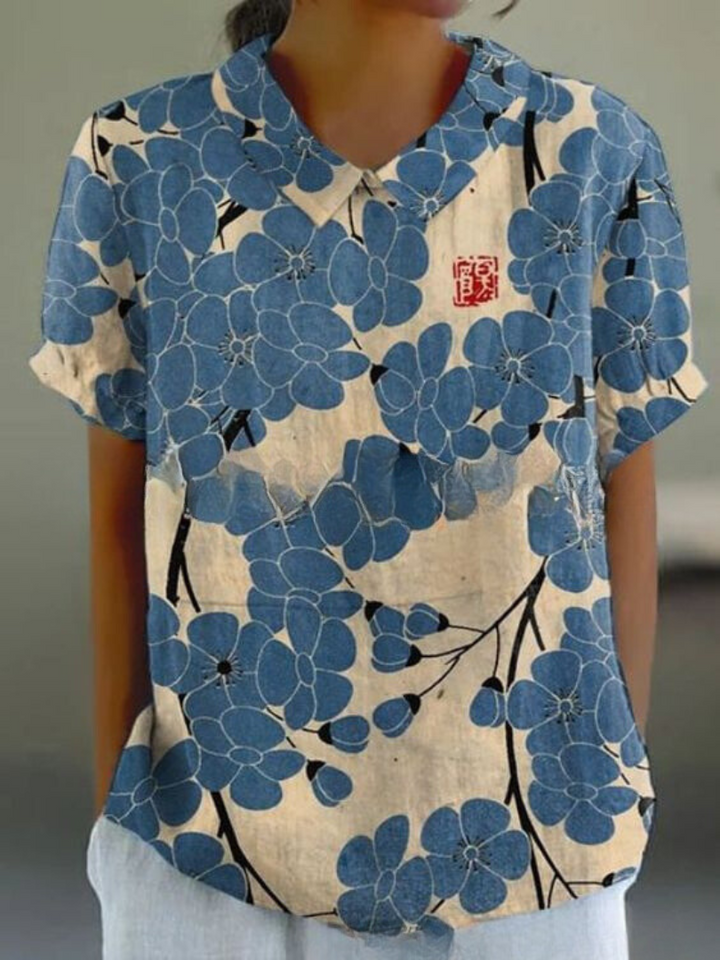 Women's elegant floral blouse with short sleeves and Peter Pan collar, featuring a vibrant floral pattern for stylish summer 